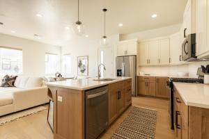 a kitchen with a sink and a couch in a room at Villa 28 - 4 Bedroom Townhome! Pool and Hot Tub! in St. George