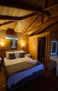 ein Schlafzimmer mit einem großen Bett in einem Holzzimmer in der Unterkunft Palmira Selimiye in Marmaris