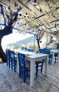 a white table with blue chairs under a tent at Palmira Selimiye in Marmaris