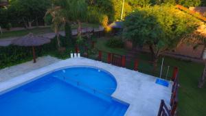 widok na duży błękitny basen w obiekcie Cabañas Ranger w mieście Santa Rosa de Calamuchita