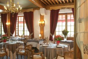 - une salle à manger avec des tables, des chaises et des fenêtres dans l'établissement Hotel Christiania, à Villard-de-Lans
