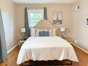 a bedroom with a bed with a white bedspread and a window at Entire Private 3 Bedrooms 1 Bathroom Single House with Fenced Garden in Arlington