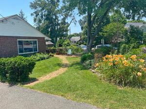 a house with a yard with flowers in the grass at Entire Private 3 Bedrooms 1 Bathroom Single House with Fenced Garden in Arlington