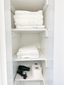 a closet with white towels and a pile of towels at Entire Private 3 Bedrooms 1 Bathroom Single House with Fenced Garden in Arlington