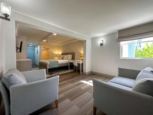 ein Wohnzimmer mit einem Bett, einem Sofa und einem Fenster in der Unterkunft Blue Haven Holiday Apartments in Christchurch