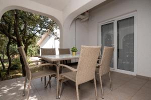 a dining table and chairs on a patio at Apartments with a parking space Mandre, Pag - 16836 in Mandre