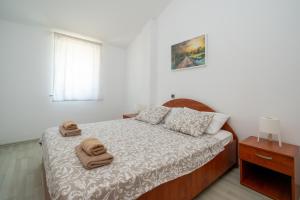 Apartments with a parking space Mandre, Pag - 16836 في ماندري: غرفة نوم عليها سرير وفوط