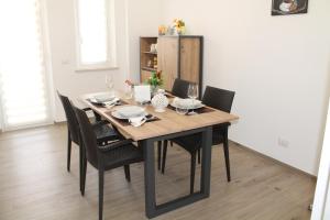 una mesa de comedor con sillas negras alrededor en Vento Di Grecale, en Erice