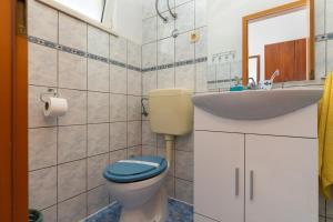 uma casa de banho com um WC e um lavatório em Apartments by the sea Duce, Omis - 13694 em Omiš