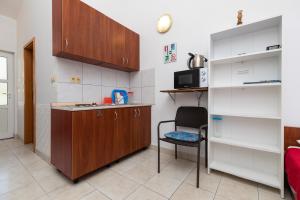 uma pequena cozinha com uma cadeira e um micro-ondas em Apartments by the sea Duce, Omis - 13694 em Omiš