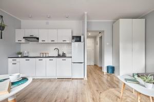 cocina con armarios blancos y mesa en LAS I GÓRY Jedlina-Zdrój. Apartament na 5, en Jedlina-Zdrój