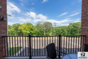 einen Balkon mit einem Zaun, Stühlen und Bäumen in der Unterkunft New Build - Walk-In 3BR Condo with Arcade Game - FREE TICKETS INCLUDED - FHG-207 in Branson