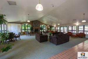 ein Wohnzimmer mit Sofas, Tischen und Fenstern in der Unterkunft New Build - Walk-In 3BR Condo with Arcade Game - FREE TICKETS INCLUDED - FHG-207 in Branson