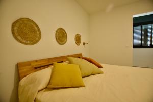 a bedroom with a white bed with yellow pillows at Caretta Beach Destino in Morro del Jable