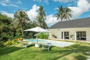 uma imagem de um quintal com uma piscina e cadeiras e um guarda-sol em Villa Kirana - Blissful Oasis with Pool & Jungle-View Garden em Ubud