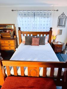 una camera con letto in legno e cassettiera di The Red Barn: right in the heart of historic Berry a Berry