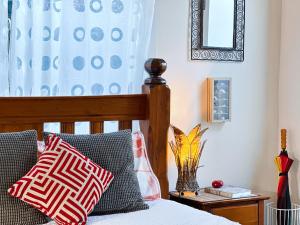 um quarto com uma cama com duas almofadas e um espelho em The Red Barn: right in the heart of historic Berry em Berry