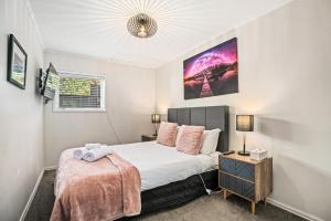 ein kleines Schlafzimmer mit einem Bett und einem Nachttisch in der Unterkunft Awesomely Lakeview Queenstown Home in Queenstown