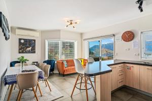 eine Küche und ein Wohnzimmer mit einem Tisch und Stühlen in der Unterkunft Awesomely Lakeview Queenstown Home in Queenstown