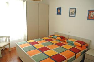 una camera da letto con un letto con una coperta colorata di Le maree Lorena a Porto Azzurro