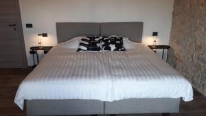 a large bed with black and white pillows on it at Agriturismo La Pina in Tarzo