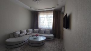 a living room with a couch and a table at Уютная трёхкомнатная для семьи in Dushanbe
