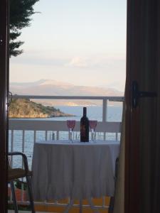 a table with two glasses and a bottle of wine at Koronis Hotel in Tolo