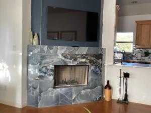 a fireplace in a living room with a stone wall at Lakeland Casita in Point Venture Optional Golf cart in Lago Vista