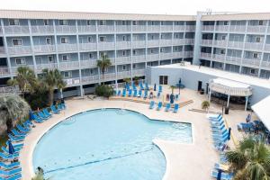 a hotel with a swimming pool and chairs and a building at Seaside Sanctuary Condo Villa - Private Beach Access, 3 Pools in Hilton Head Island