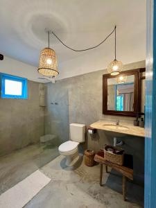 a bathroom with a toilet and a sink and a mirror at Pousada Caraíva in Caraíva +49 photos