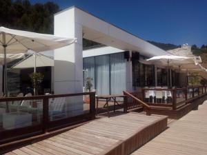 a building with tables and umbrellas on a deck at Sesimbra Flat in Sesimbra