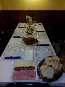 a long table with plates of food and wine glasses at Hostal Juventus in Portbou