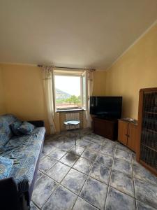 a room with a couch and a tv and a window at Casa Vacanze Primavera in Maratea