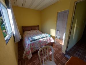 niewielka sypialnia z łóżkiem i oknem w obiekcie Teresópolis Hostel w mieście Teresópolis