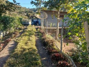 Teresópolis Hostel في تيريسوبوليس: حديقة بها دراجة نارية متوقفة بجوار سياج