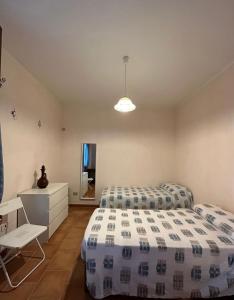 1 dormitorio con 2 camas y TV en Casa Vacanze Primavera en Maratea