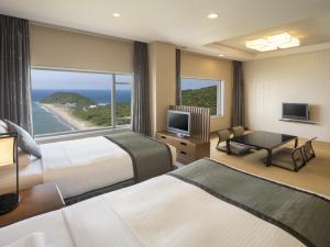 a hotel room with two beds and a view of the ocean at Irago Ocean Resort in Tahara