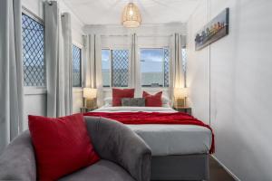 a bedroom with a large bed with red pillows at Family Fun Your beach and fishing delight in Rockingham