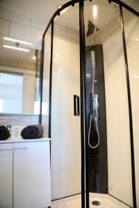 a shower in a kitchen with a glass wall at Jupiter in Saint-Quentin
