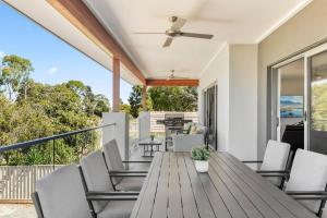 a deck with a wooden table and chairs at NEW - Sunrise Waters Holiday House in Mulwala