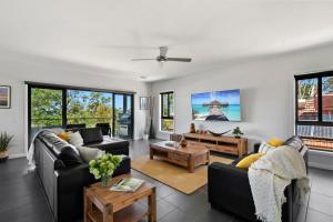 a living room with two couches and a table at NEW - Sunrise Waters Holiday House in Mulwala