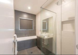 a bathroom with a shower and a sink and a mirror at NEW - Sunrise Waters Holiday House in Mulwala
