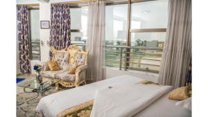um quarto com 2 camas, uma cadeira e uma janela em Marriot Metropolitan Hotel em Douala