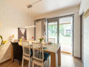 een keuken en eetkamer met een houten tafel en stoelen bij Snug apartment in Houthalen Oost with heated pool in Drijhoeven