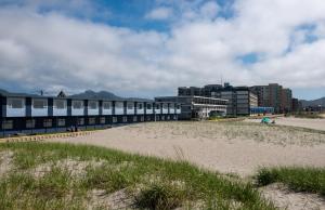 a sandy beach next to a building on a beach at The Ocean Front at Seaside in Seaside