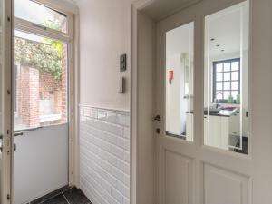 una puerta giratoria en un baño con ventana en Scenic villa in Borgloon with garden, en Borgloon 33 fotos más