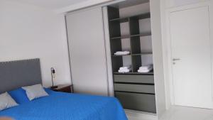 1 dormitorio con cama azul y armario en Oportunidad Departamento a Estrenar 2 ambientes hasta 4 personas Mar del plata 12 cuadras del MAR en Mar del Plata