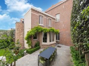 un patio con mesa y sillas frente a un edificio de ladrillo en Historic building with a high level of finishing in Borgloon en Borgloon