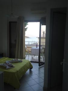 a bedroom with a bed and a view of the ocean at Koronis Hotel in Tolo