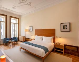 une chambre d'hôtel avec un lit et une chaise dans l'établissement Casa do Arquiteto - Townhouse - Architect's House, à Porto